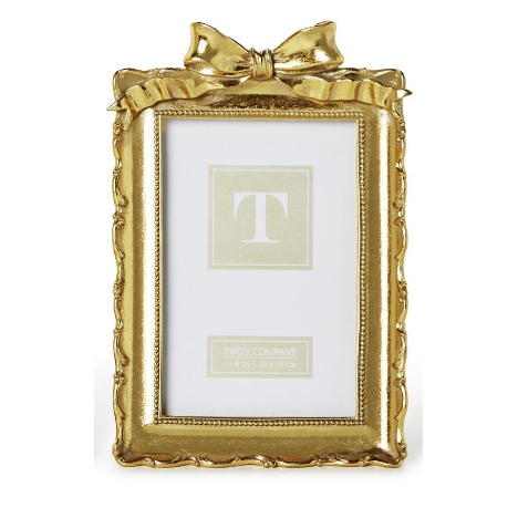 Two gold picture frames with decorative bows on a white background