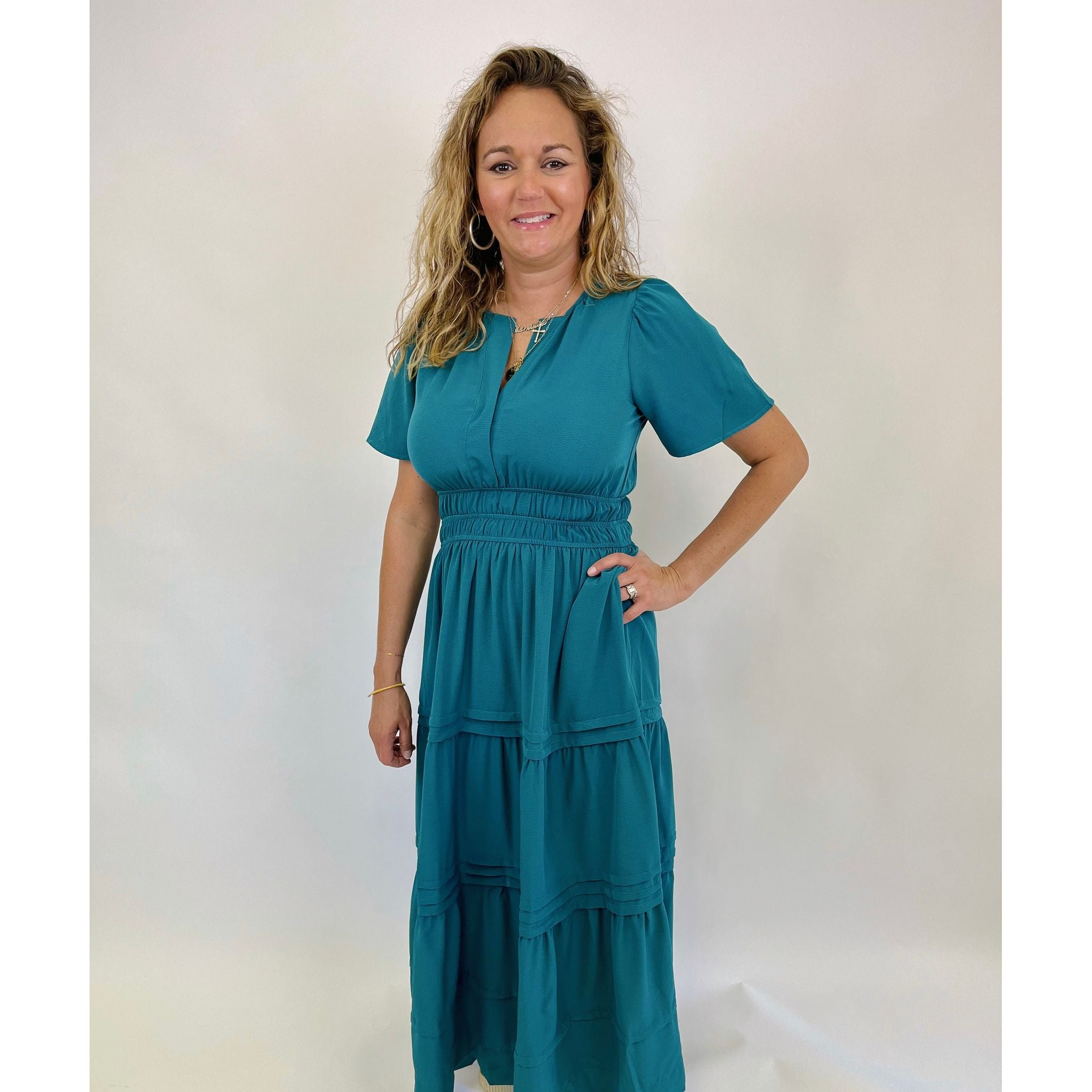 Experience the perfect blend of style and comfort with our Taylen Dress! This teal colored dress boasts a flattering fit and short sleeves, making it the ideal choice for any fall photo session. The maxi length adds a touch of elegance, ensuring you'll capture every moment in stunning fashion.

Olivia is wearing a size small.