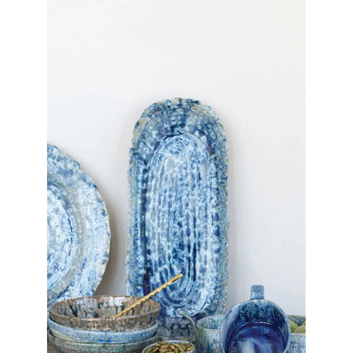 Set of blue ceramic dishes on a wooden surface with a white background
