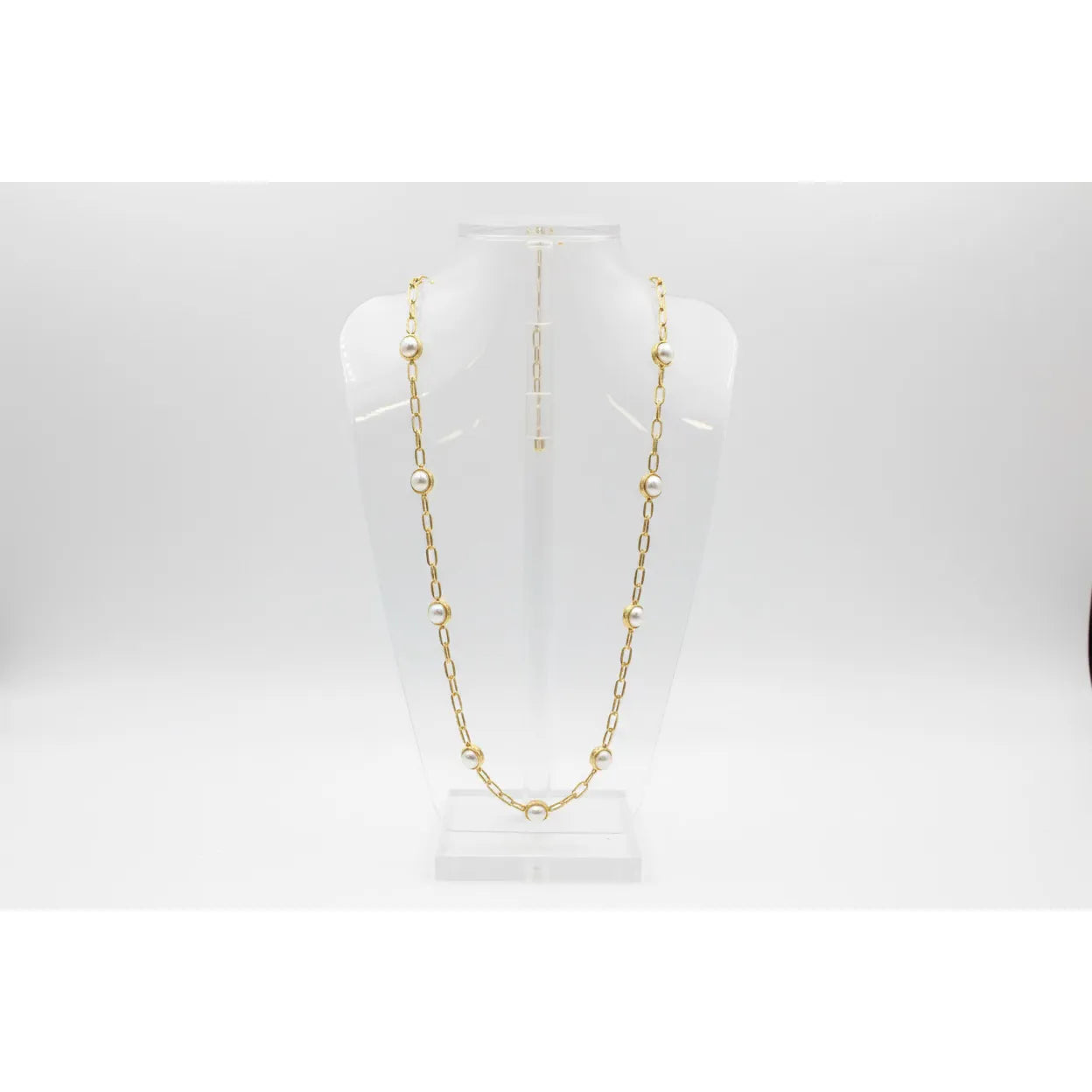 Gold chain necklace on a white mannequin bust against a white background