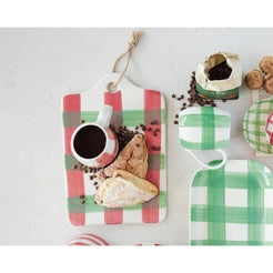 Set of green and red checkered trays with food items on a light gray background