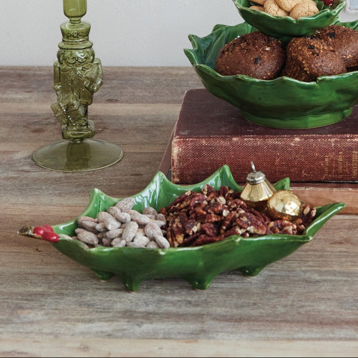 Decorative setup with green bowls, candles, and a small gold tree on a wooden surface.